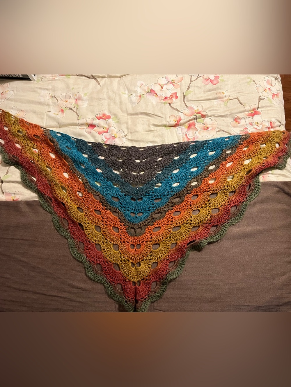 Hand-Crocheted Triangle Shawl Featuring a Vibrant Multicolor Gradient Pattern.